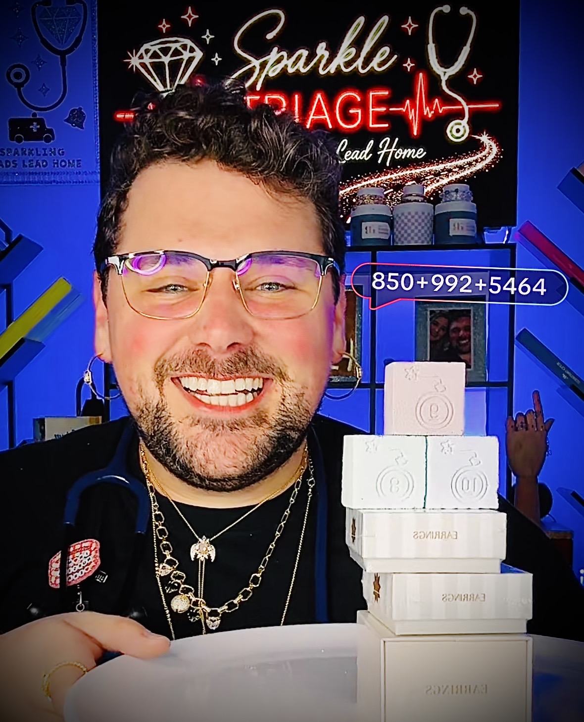 Adam smiling during a Sparkle Triage live with Bomb Party jewelry boxes